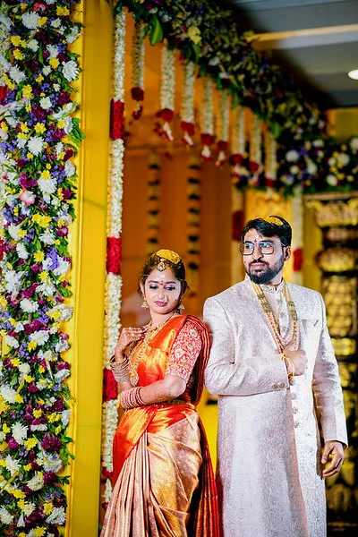 Vihari and Pranaya standing beside a floral wedding canopy