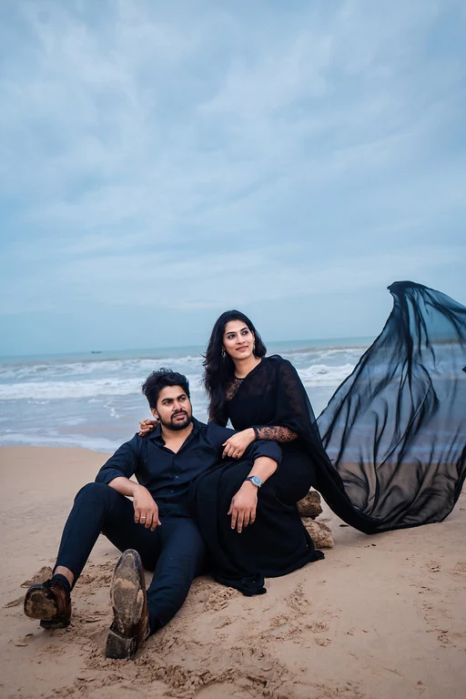 A couple on the beach beneath a soft evening sky