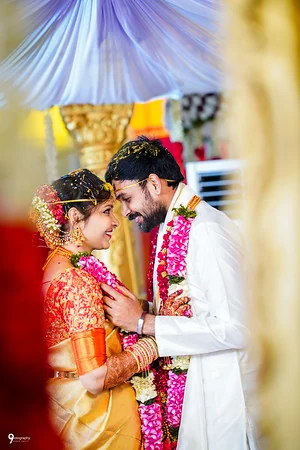 Anirudh and Kavya leaning together beneath their wedding canopy