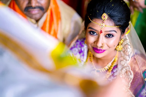 Likhitha during a wedding ceremony, framed by a ritual cloth